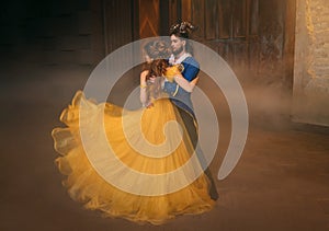 couple is dancing at fantasy ball. Happy beauty woman princess in yellow dress and guy enchanted guy, horns on head