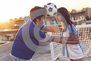 Couple dancing with a football between their heads