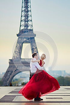 Couple dancing in front of the Eiffel tower in Paris, France