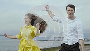 Couple dancing together at the embankment in the city. View of their foots