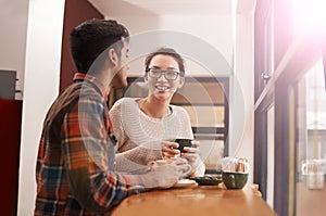 Couple, date and coffee shop with smile and talking together with hot drink in a cafe. Woman, conversation and happy