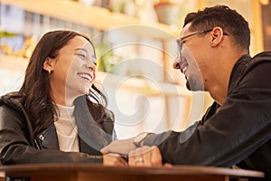 Couple, date and man happy with woman in a restaurant, coffee shop or cafe together bonding and funny conversation