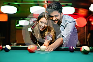 Couple dating, flirting and playing billiard in a pub