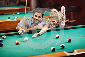Couple dating and spending time together by playing billiard