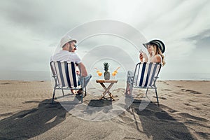 Couple on a deck chair relaxing on the beach.