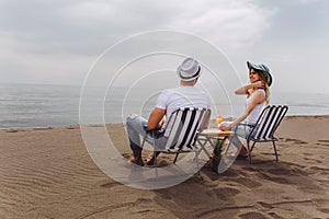 Couple on a deck chair relaxing on the beach.