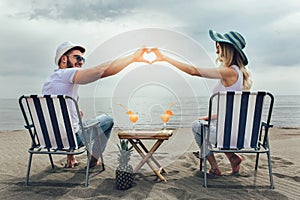 Couple on a deck chair relaxing on the beach.