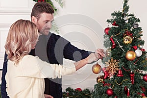 Couple decorating Christmas tree