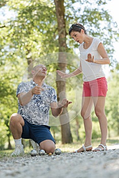 couple disagreeing over game boules in park