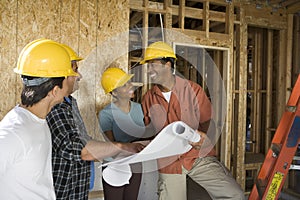 Couple Discussing Construction Plans With Contractors photo