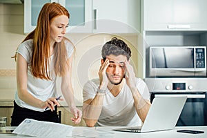 Couple discussing about domestic bills at home while looking at documents