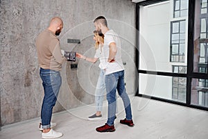 Couple discussing interior with designer in new apartment.