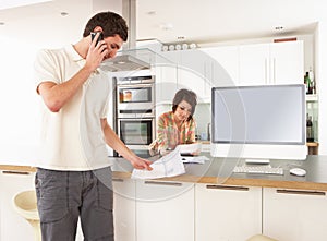 Couple Discussing Personal Finances In Kitchen