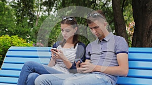 Couple In Disinterest Moment With Phones Outdoors