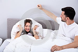 Couple disturbed by noise on bed photo