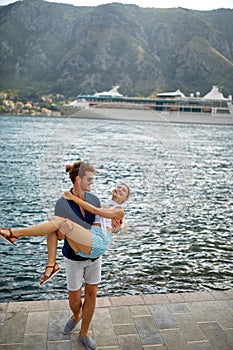 Couple on dock. Man holding woman in his arms. Beautiful sea view enjoying freedom. Travel, love, fun, togetherness, lifestyle