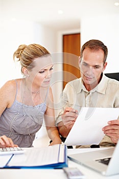 Couple, documents and financial bills for planning, taxes and reading report, budget or letter of mortgage payment. Man