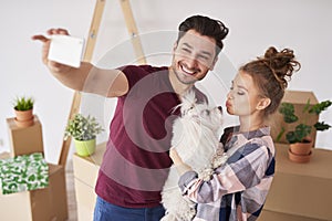 Couple with dog making a selfie in new home