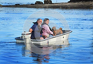 Couple with dog on small boat