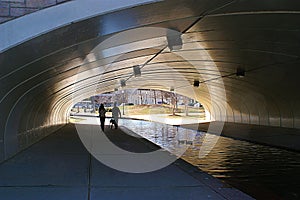 Couple with Dog Walking Under Tunnel