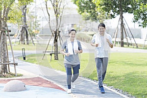 Couple doing exercising by running in the garden. Sporty mature couple styaing fit with sport