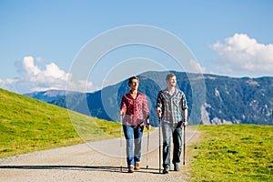 Couple doing nordic walking exercise in mountains