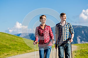 Couple doing nordic walking exercise in mountains