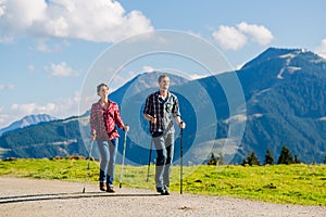 Couple doing nordic walking exercise in mountains