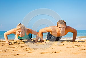 Couple doing push ups on the beach