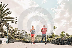 Couple doing running training session outdoor - Sporty people workout sprint exercises