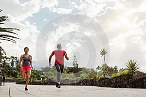 Couple doing running training session outdoor - Sporty people workout sprint exercises