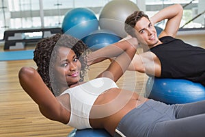 Couple doing sit ups on exercise balls