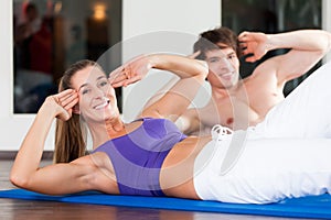 Couple doing sit ups in gym