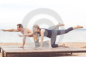 Couple are doing sports at sea coast