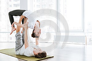 Couple doing stretching exercises in yoga studio