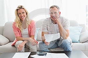 Couple doing their accounts sat in a couch