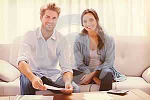 Couple doing their accounts sat in a couch