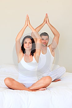 Couple doing yoga in bed