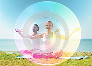 Couple doing yoga in lotus pose with rainbow aura