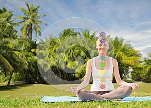 Couple doing yoga in lotus pose with seven chakras