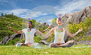 Couple doing yoga in lotus pose with seven chakras