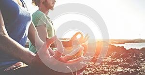 Couple doing yoga outdoor at sunrise in nature - Woman and man meditating together at morning time - Concept of fitness exercise