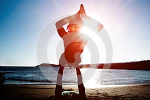 Couple doing yoga outdoor at sunrise in nature - Woman and man meditating together at morning time - Concept of fitness exercise