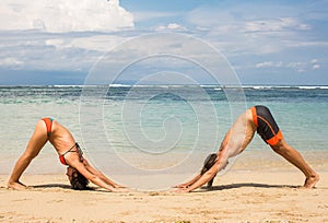 Couple doing yoga and relaxation exercises by the sea