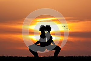 Couple doing yoga at sunset