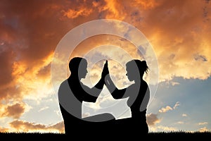 Couple doing yoga at sunset