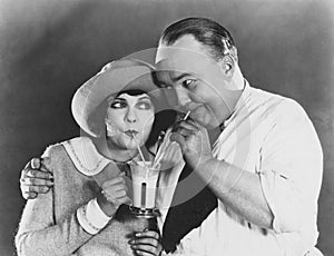 Couple drinking beverage with straw