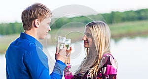 Couple drinking champagne outdoors enjoying their summer holidays.