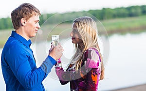 Couple drinking champagne outdoors enjoying their summer holidays.