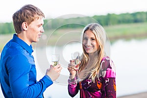 Couple drinking champagne outdoors enjoying their summer holidays.